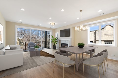 A modern living room with a fireplace and a dining table set up.