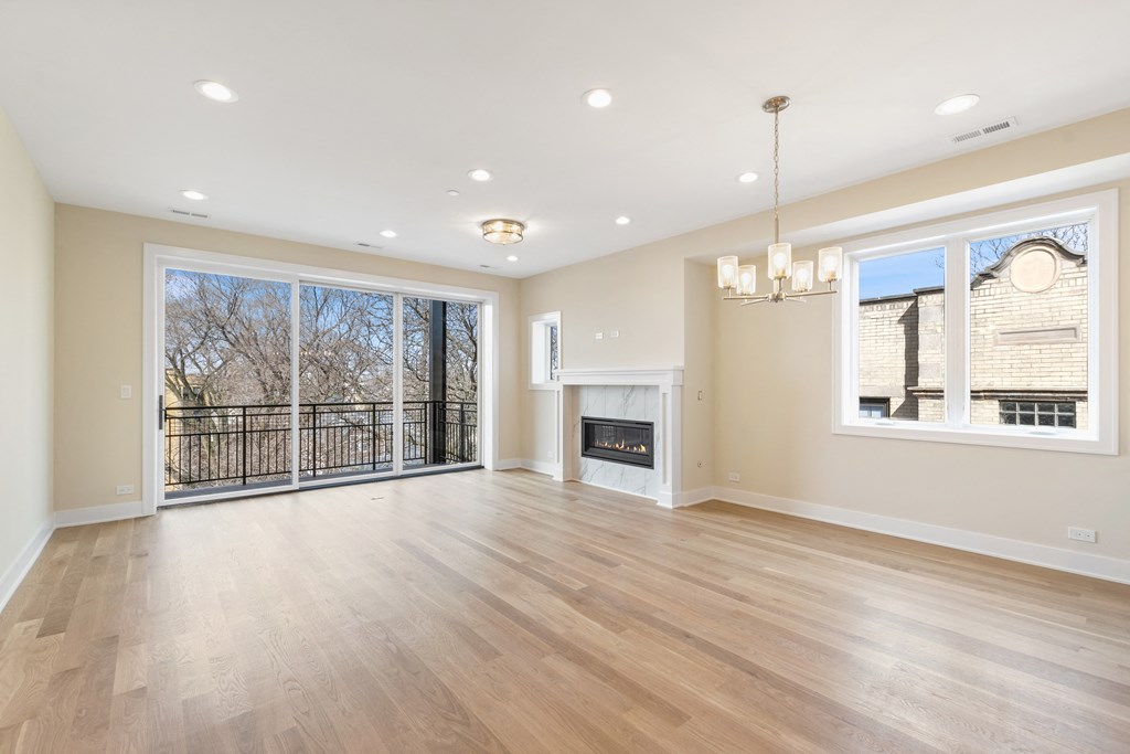 an empty living room with a fireplace and a large window
