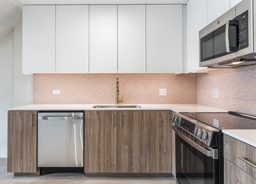 A kitchen with a brick backsplash and wooden cabinets.
