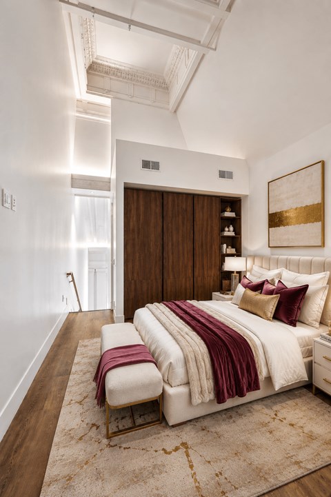 A bedroom with a large bed and a wooden headboard.