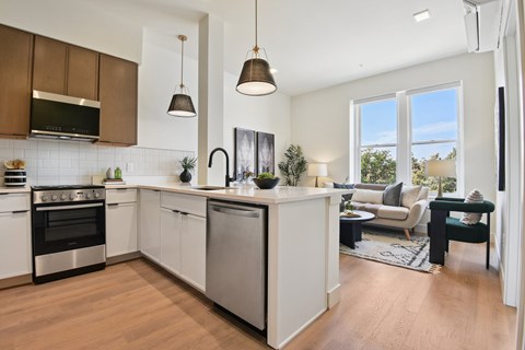 A modern kitchen with white cabinets and stainless steel appliances.