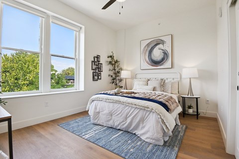 A bedroom with a large bed and a ceiling fan.