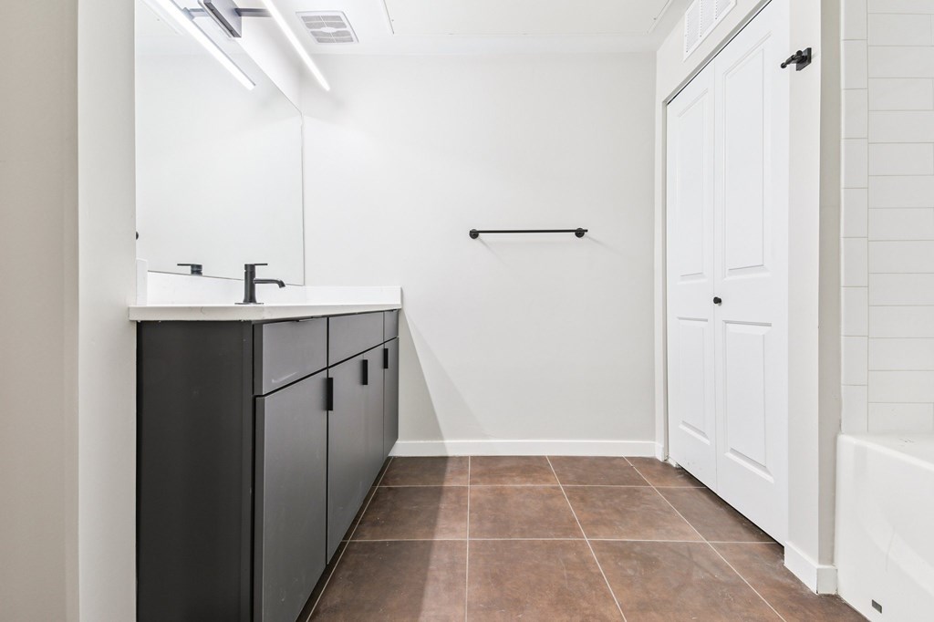 A bathroom with black cabinets and a white door.