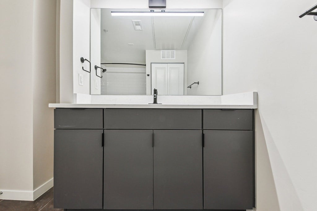 A bathroom vanity with a mirror above it.