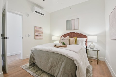 A bedroom with a bed, nightstand, and lamp.