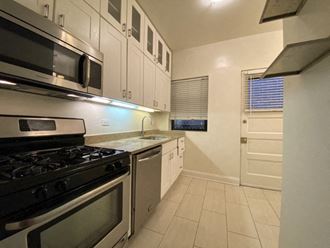a kitchen with white cabinets and stainless steel appliances