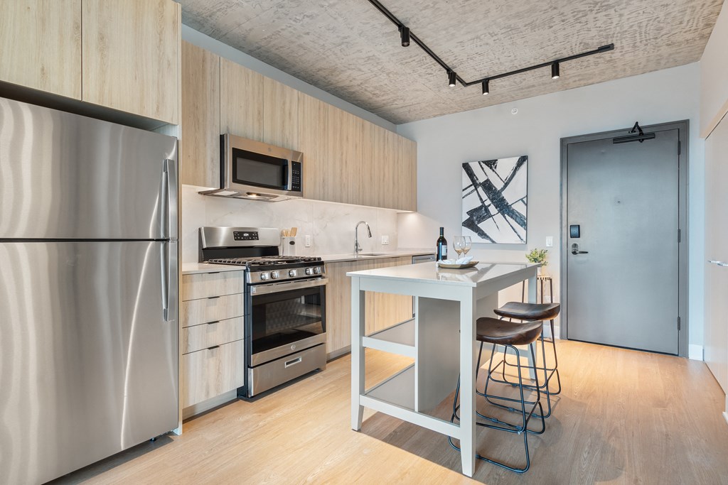 a kitchen with a island and stainless steel appliances and a stainless steel refrigerator