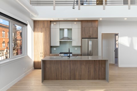 a kitchen with a wooden island and a stainless steel refrigerator