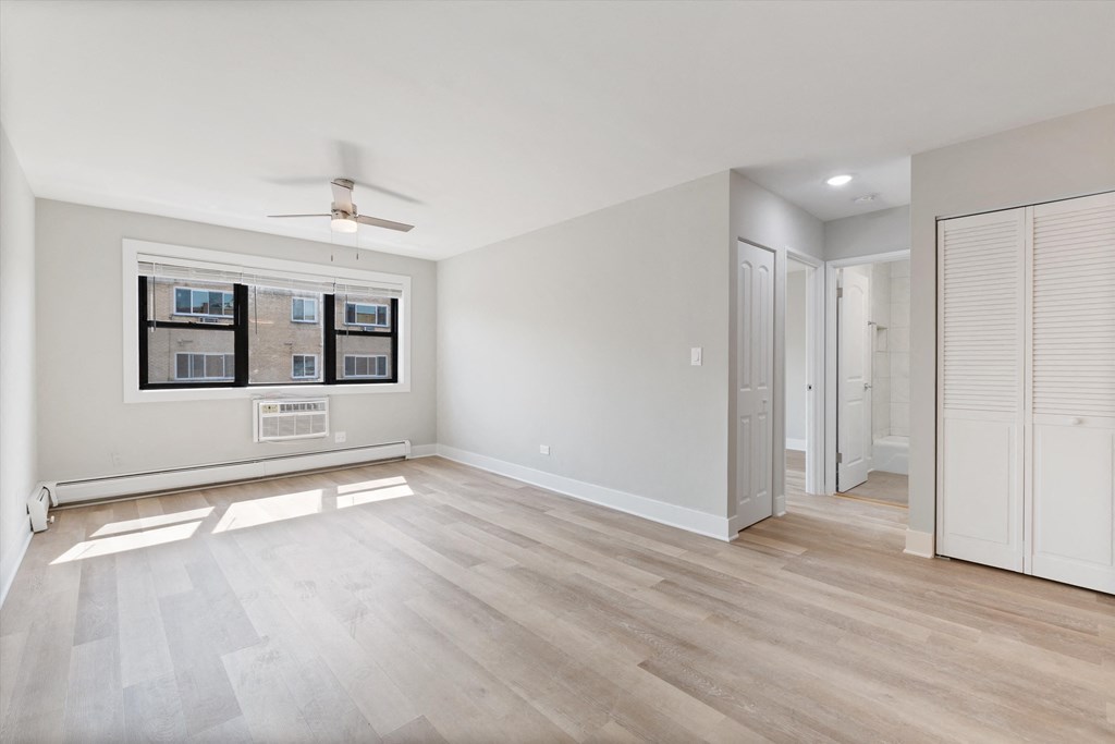 a bedroom with hardwood flooring and a ceiling fan