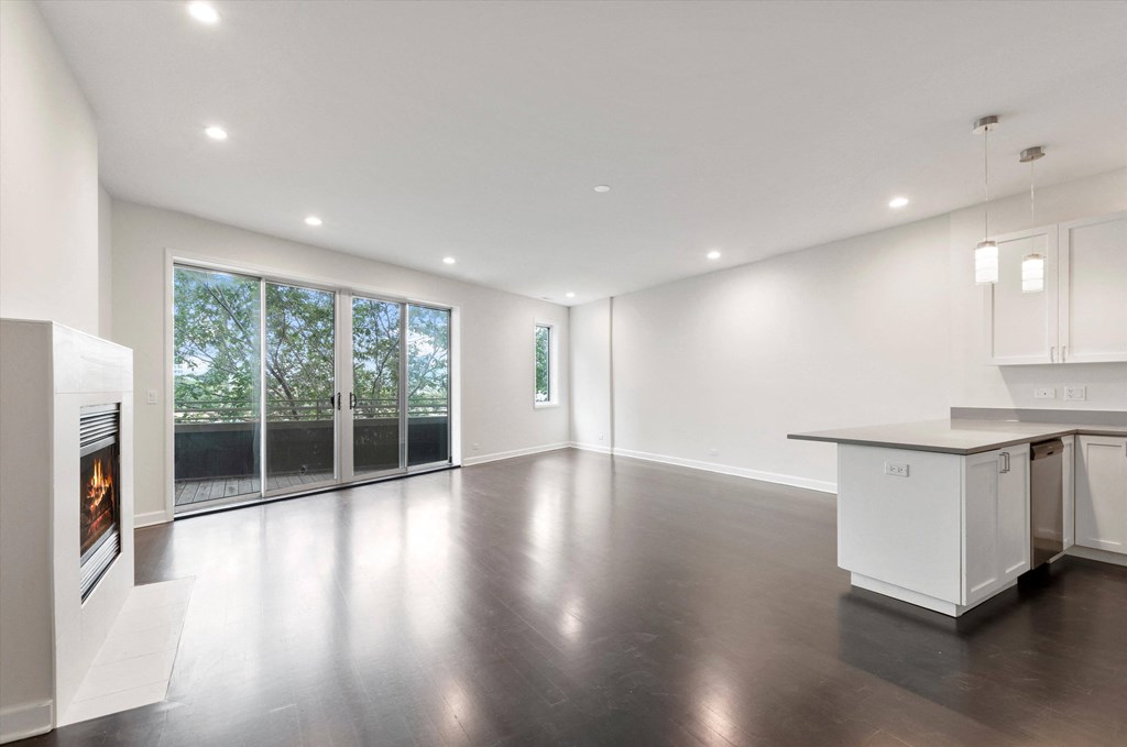 a living room with a fireplace and a kitchen