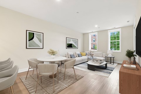 A modern living room with a white table and grey chairs.