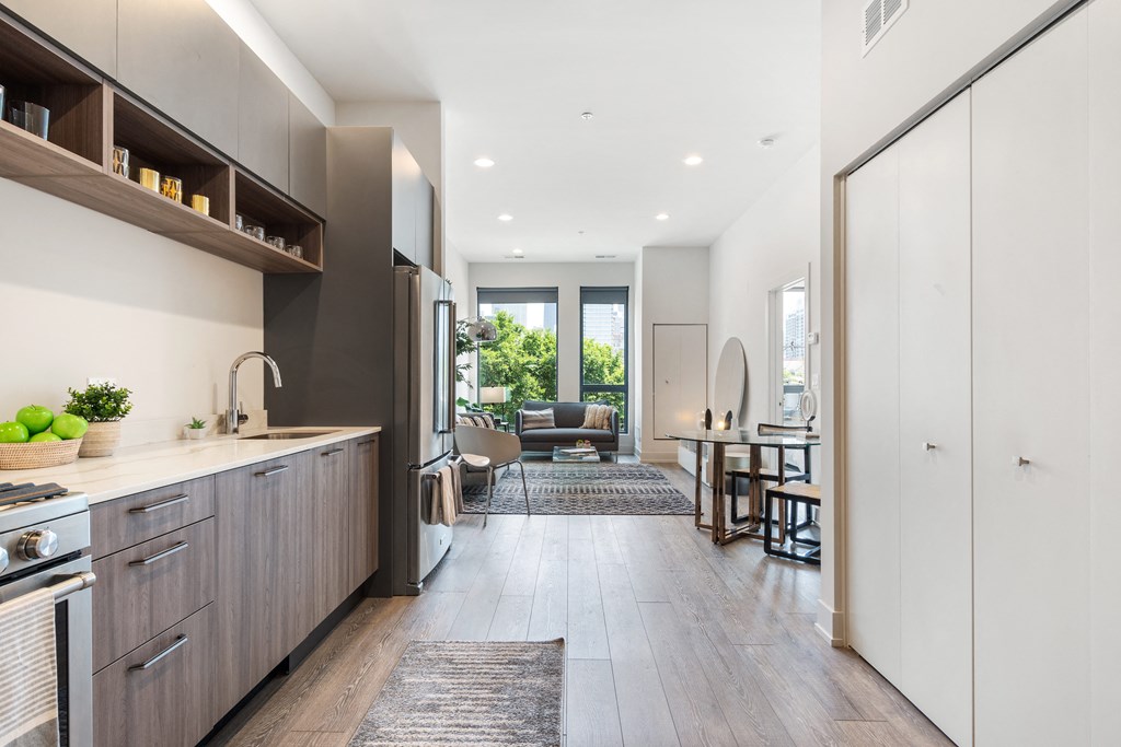 An open concept kitchen leading to a living room with large windows