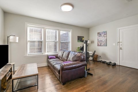 A living room with a brown leather couch and a wooden coffee table.