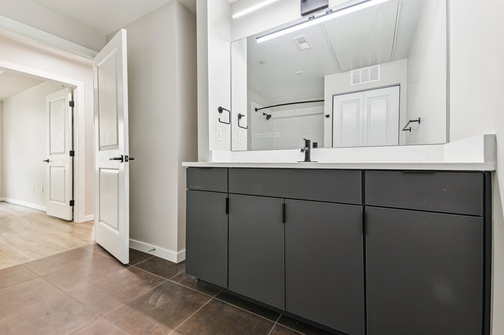 A bathroom with a large mirror and a sink.