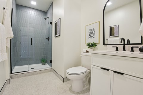 A bathroom with a toilet, sink, and shower.