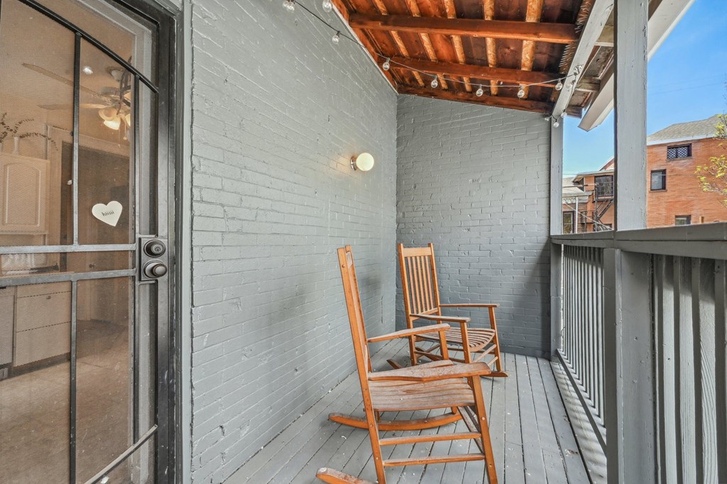 two wooden rocking chairs on a porch with a glass door