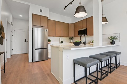A kitchen with a white counter and a stainless steel refrigerator.