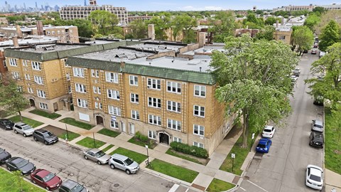 A view of a street with cars and apartment buildings.