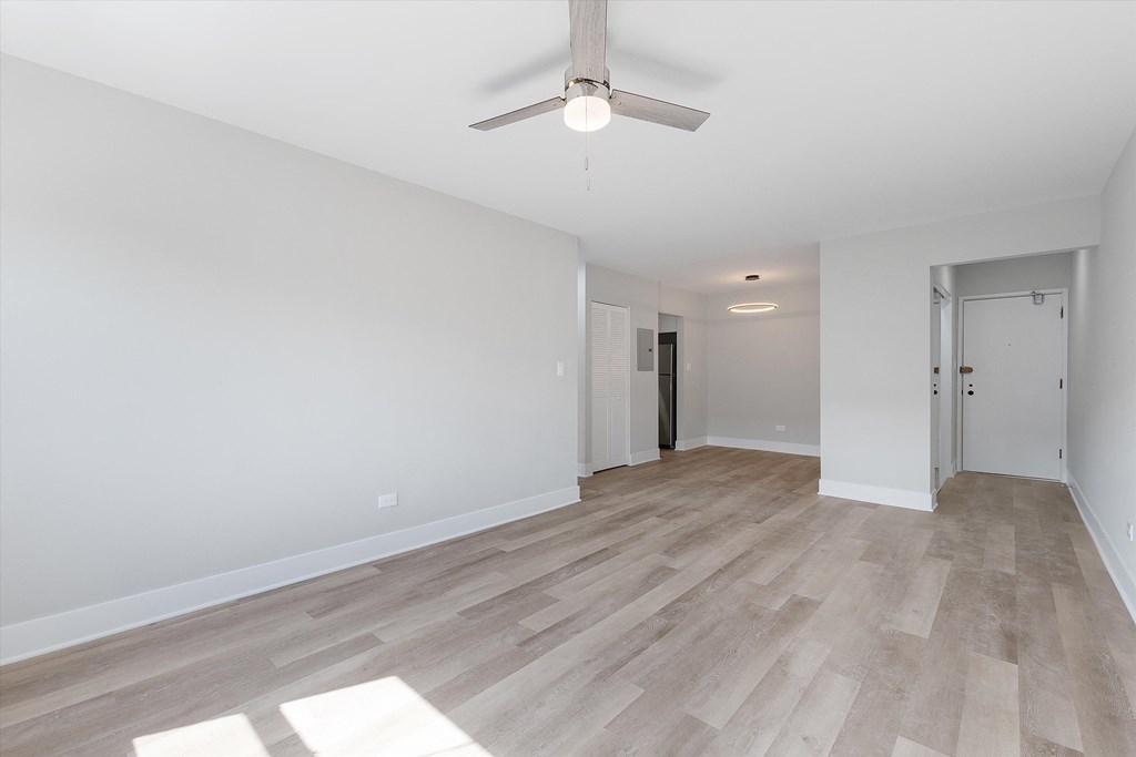 a bedroom with hardwood flooring and a ceiling fan
