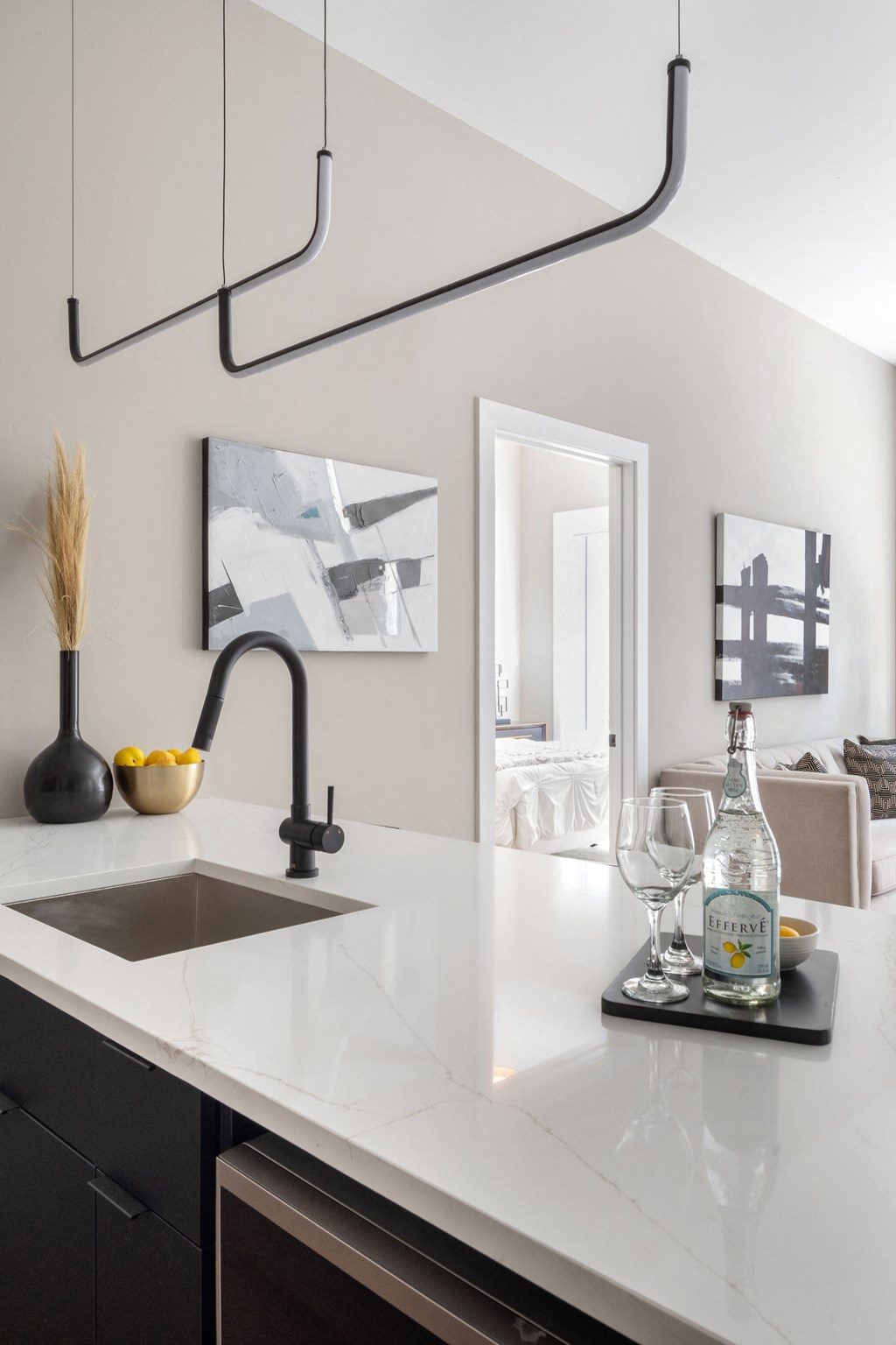 a kitchen counter with a sink and a bottle of wine