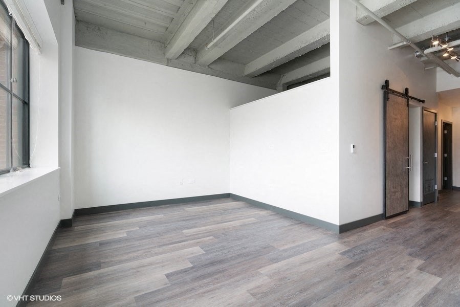 an empty room with white walls and wood floors