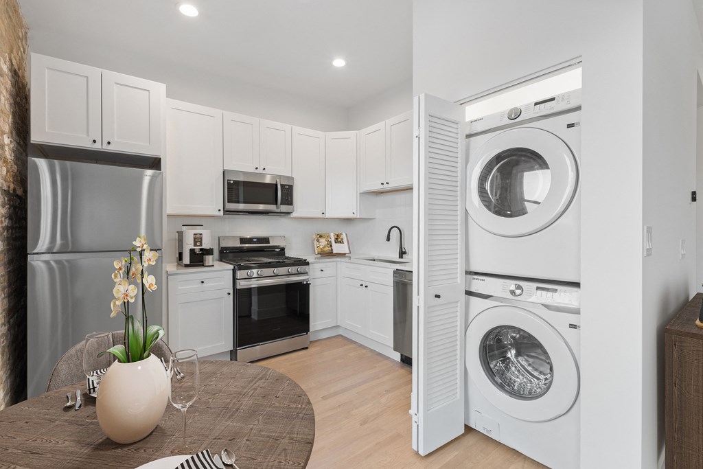a white kitchen with a washing machine and a washer and dryer in it