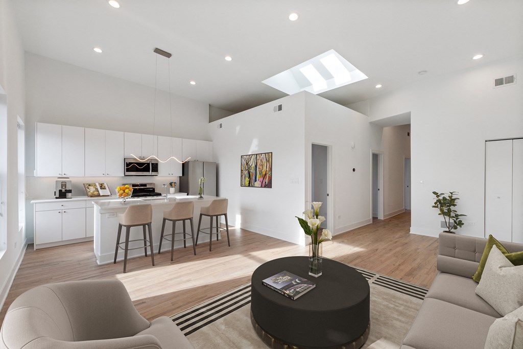 a living room with a couch and a coffee table in front of a kitchen