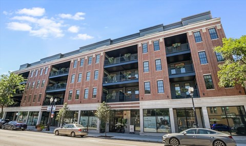A red brick building with balconies on the second floor.