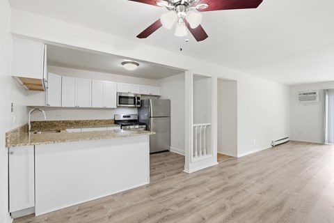 A kitchen with a counter and a fan.