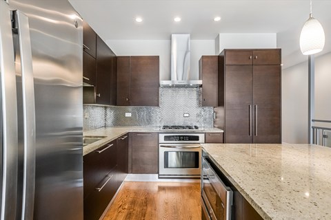 A modern kitchen with a stainless steel refrigerator and wooden countertops.