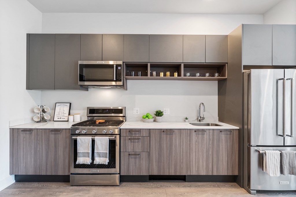 A kitchen with gray cabinets and brand-new stainless steel appliances