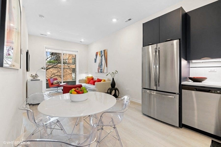 a kitchen with stainless steel appliances and a table and chairs