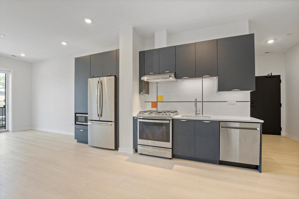 a modern kitchen with stainless steel appliances and black and white cabinets