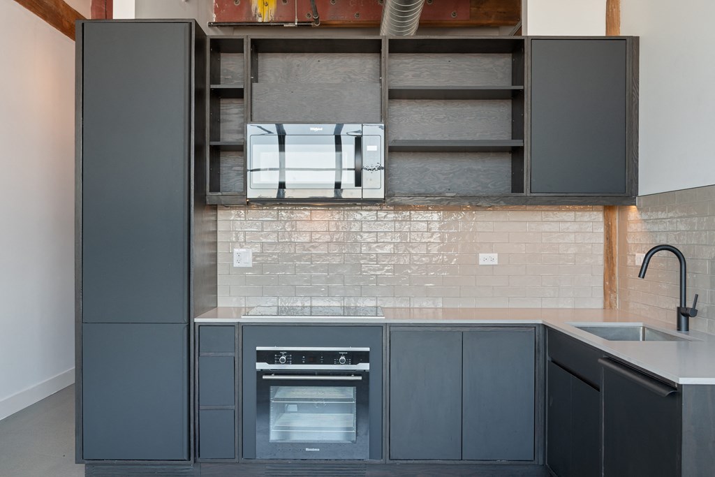 a kitchen with gray cabinets and a white counter top