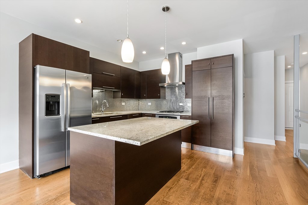 A modern kitchen with a center island and stainless steel appliances.