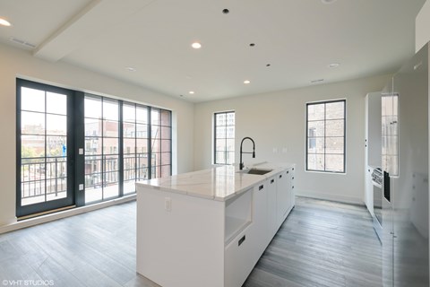 A spacious kitchen with white cabinets and a large island.