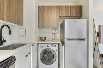 a kitchen with white cabinetry and a white washer and dryer