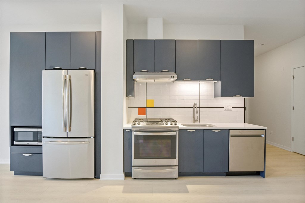 a kitchen with stainless steel appliances and gray cabinets