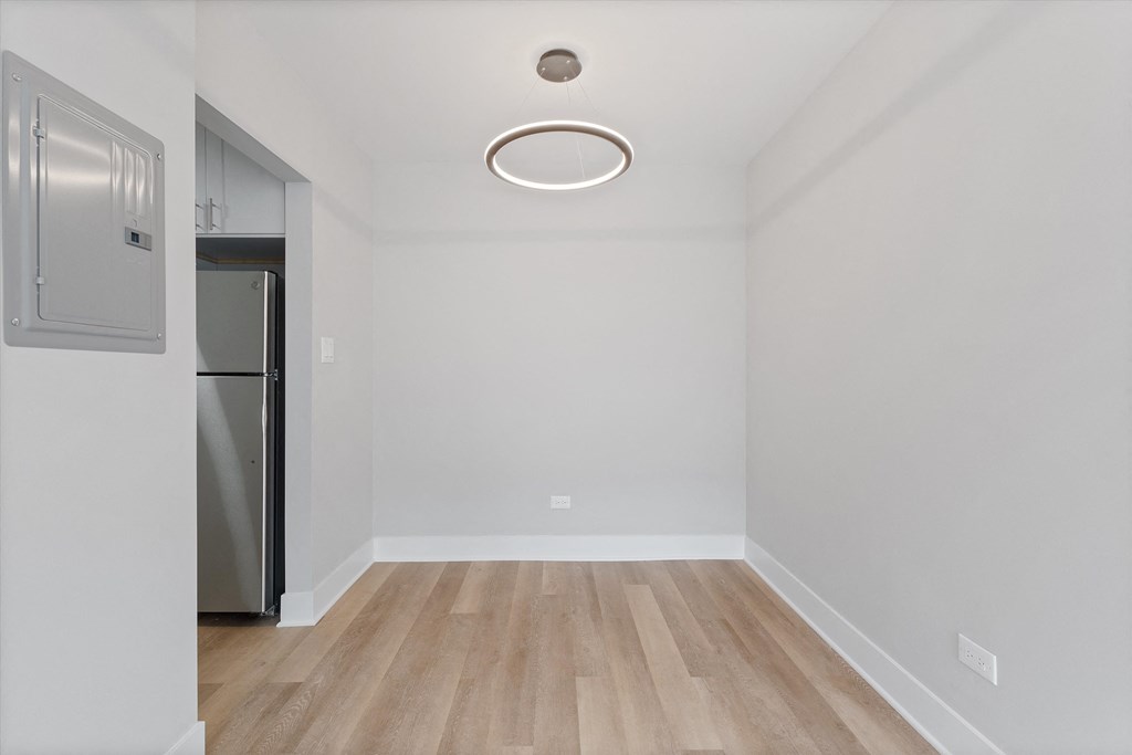 a bedroom with a medium hardwood floor and white walls