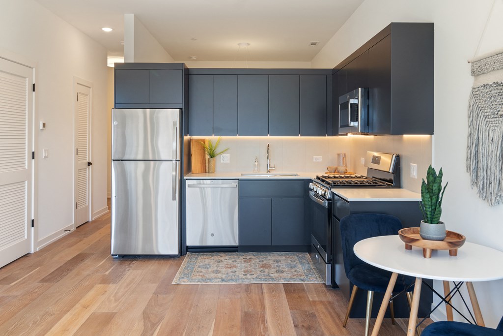 a kitchen with blue cabinets and a stainless steel refrigerator