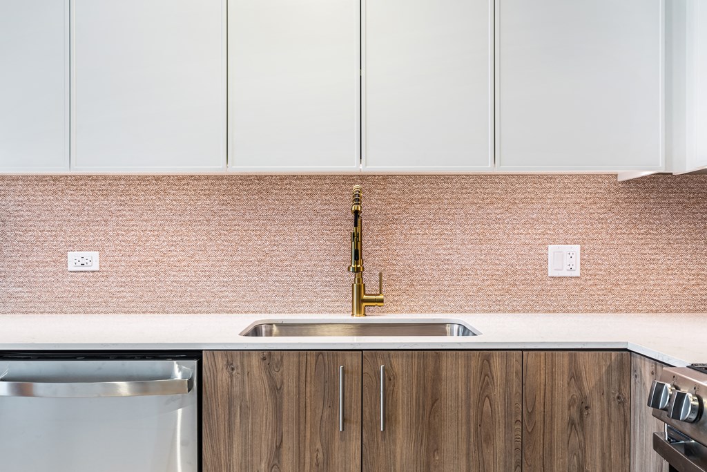A kitchen with a sink and a stainless steel dishwasher.