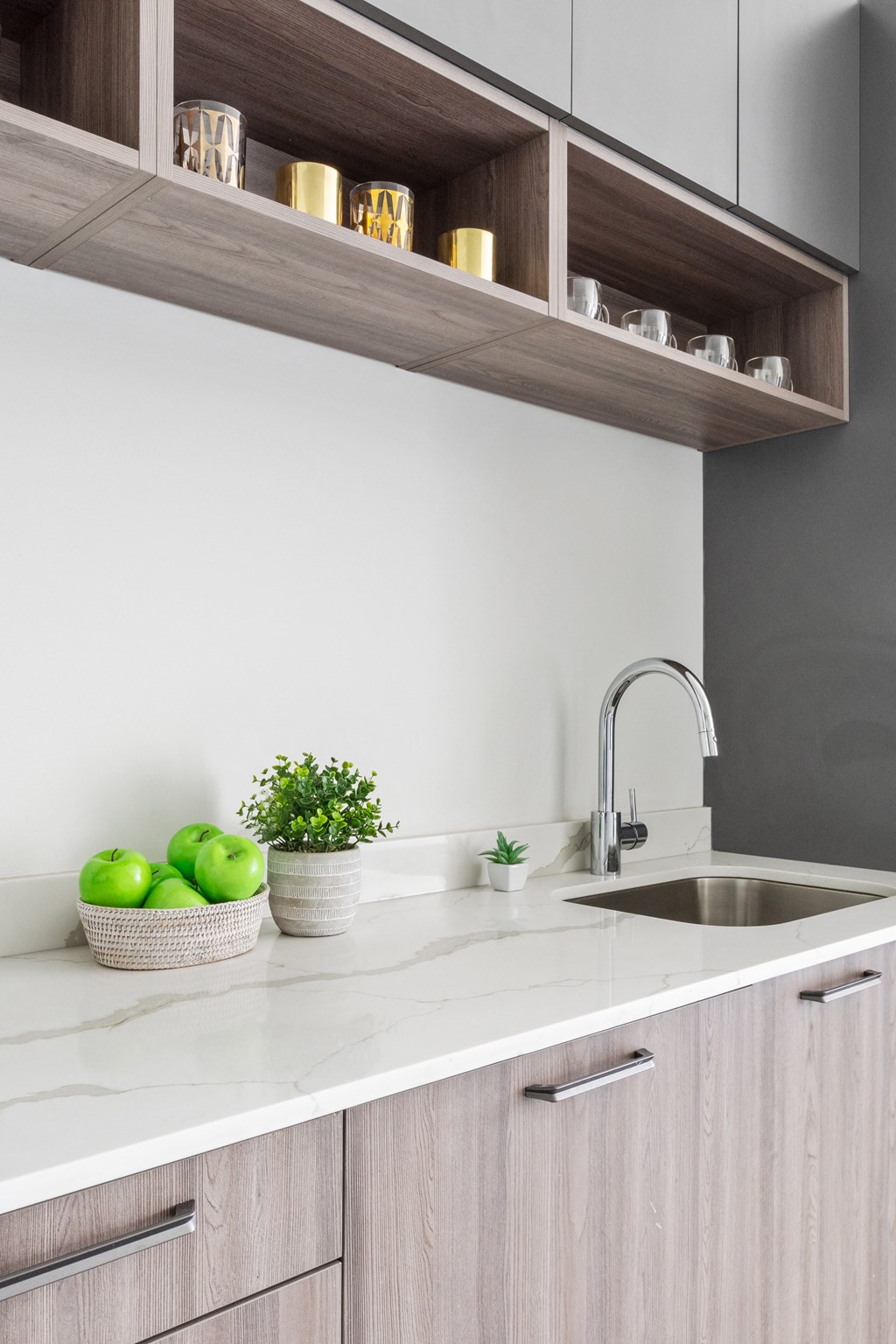 A close up of the bowl with green apples on the white countertop in the kitchen
