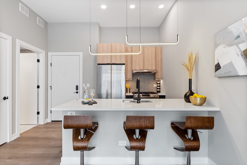 a kitchen with a white counter top and wooden stools