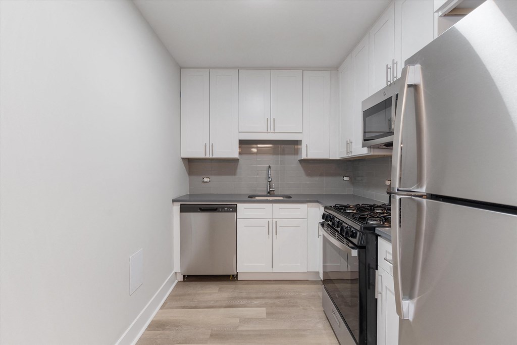 a kitchen with white cabinets and stainless steel appliances