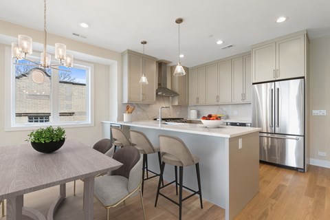 A modern kitchen with a dining table and chairs.