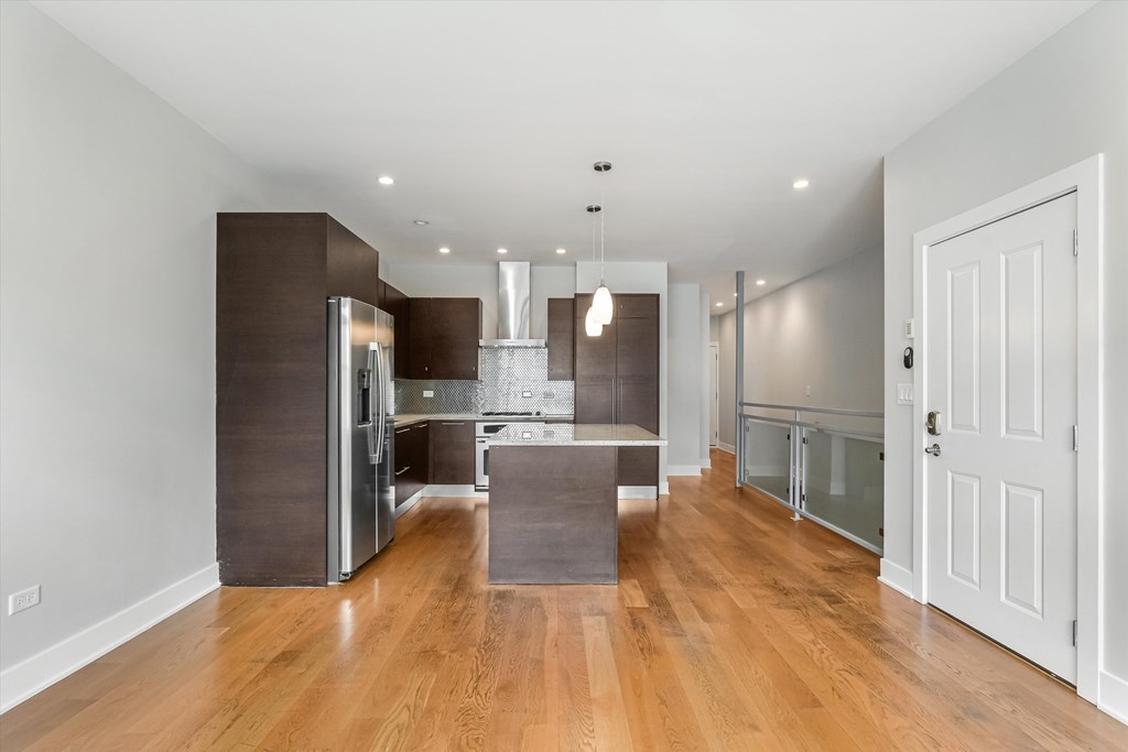 A modern kitchen with wooden floors and a large island.