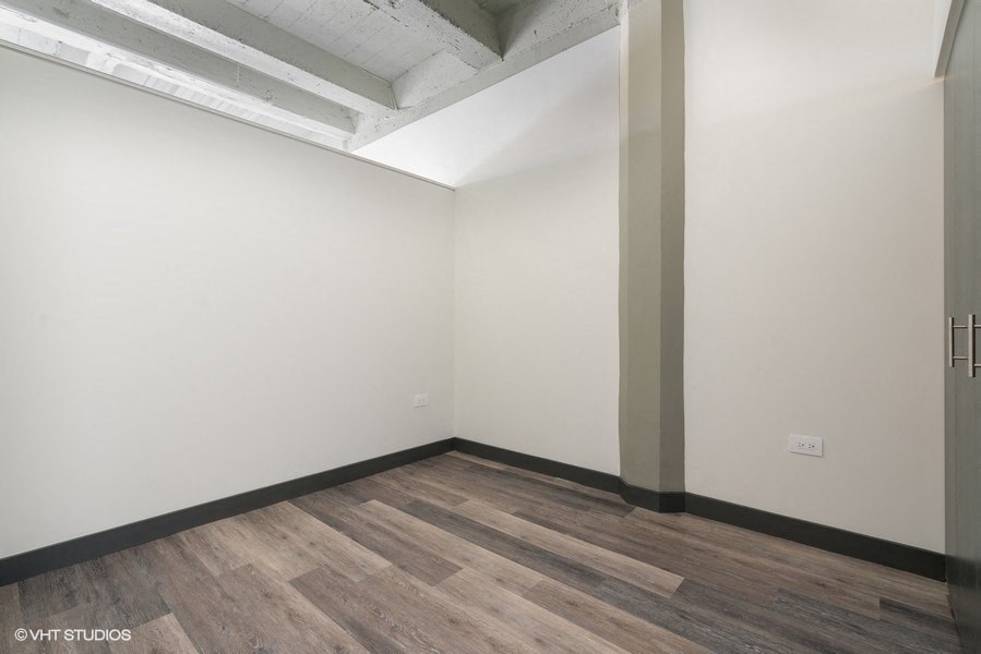 an empty room with wood floors and white walls