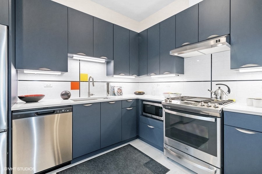 a modern kitchen with blue cabinets and stainless steel appliances