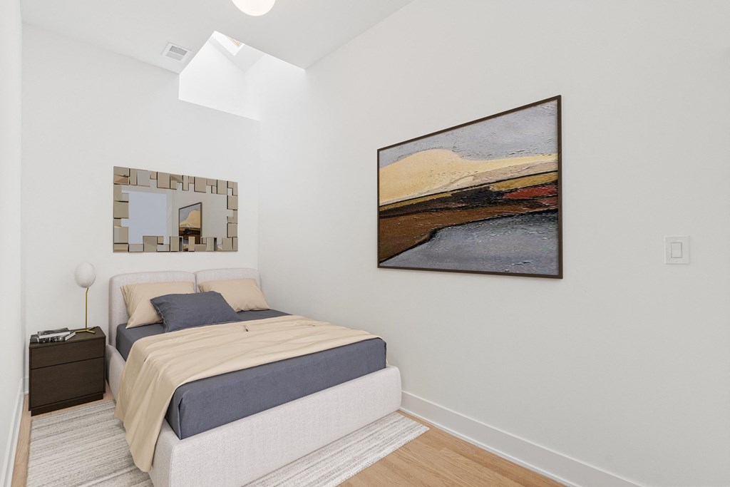 a bedroom with a bed and a painting on the wall