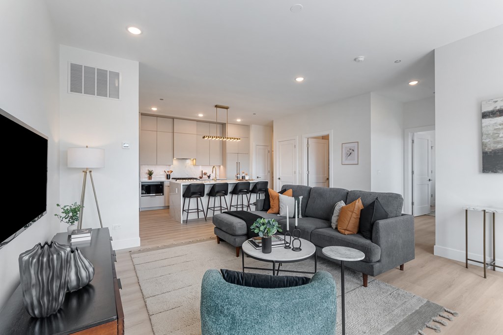 A modern living room with a grey couch and a black coffee table.